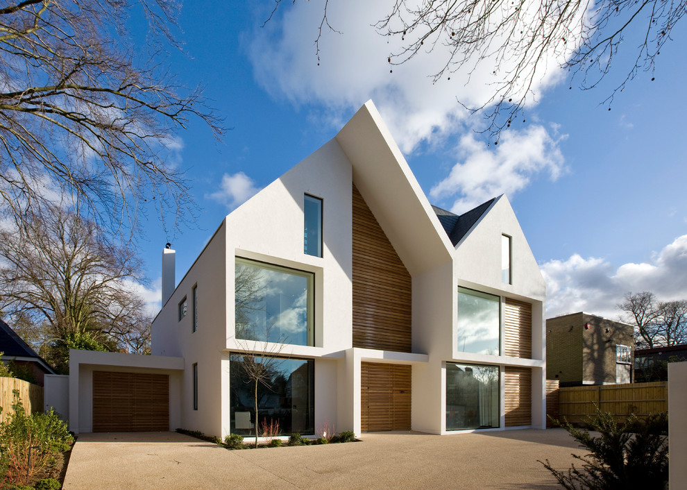 This is an example of a large and white contemporary detached house in London with three floors and mixed cladding.