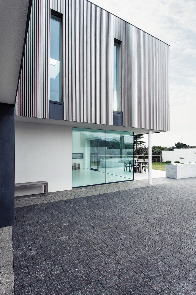 Idées déco pour une grande façade de maison grise contemporaine en bois à un étage avec un toit plat.