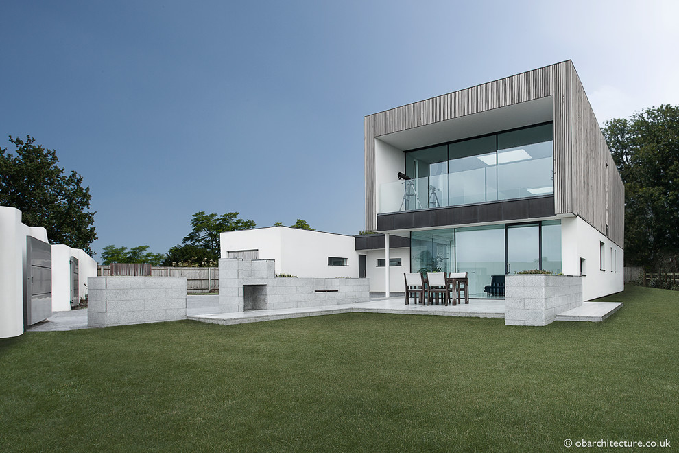 Свежая идея для дизайна: большой, двухэтажный, деревянный, серый частный загородный дом в современном стиле с плоской крышей - отличное фото интерьера