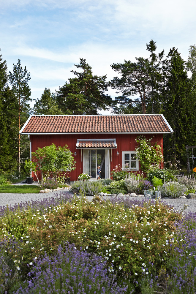 Idee per la facciata di una casa rossa country a un piano di medie dimensioni con rivestimento in legno e tetto a capanna