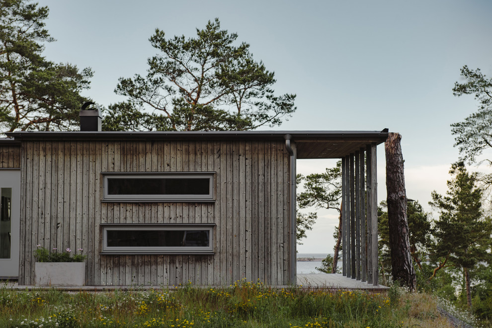 Пример оригинального дизайна: одноэтажный, деревянный частный загородный дом среднего размера в скандинавском стиле с плоской крышей
