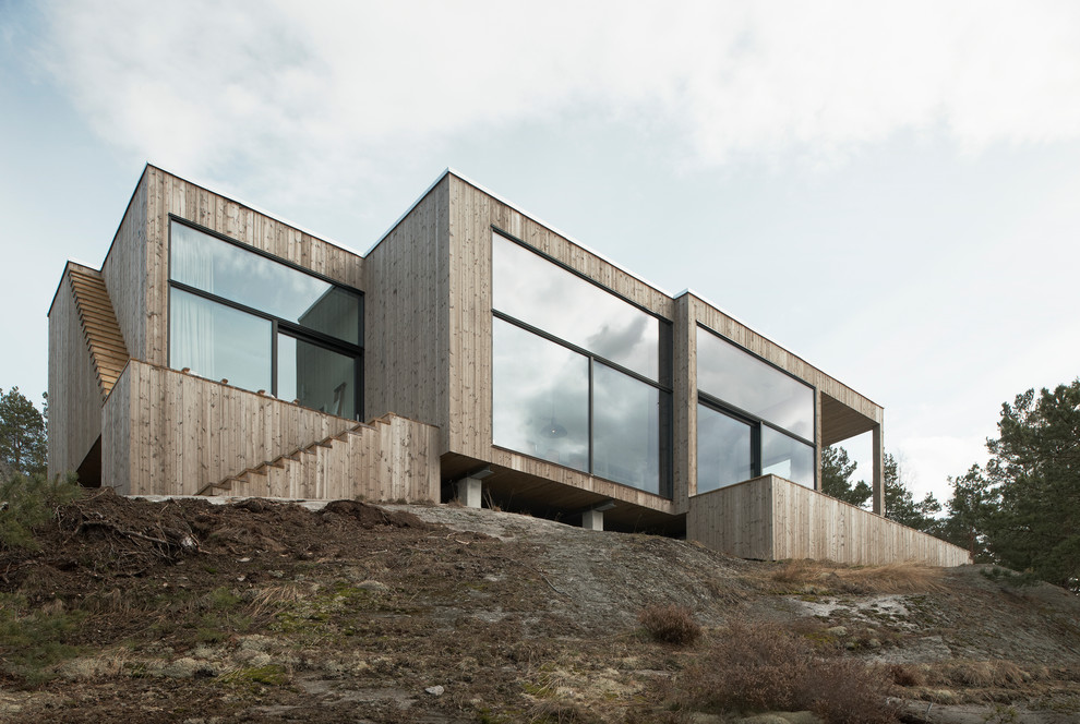 Immagine della facciata di una casa ampia beige scandinava a due piani con rivestimento in legno e tetto piano
