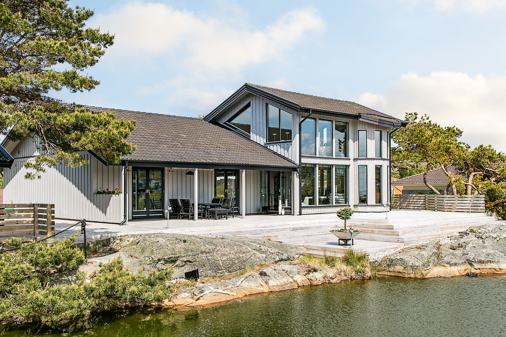 Свежая идея для дизайна: двухэтажный, деревянный, бежевый, большой дом в скандинавском стиле с двускатной крышей - отличное фото интерьера