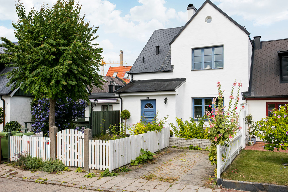Стильный дизайн: большой, двухэтажный, белый дом в скандинавском стиле с облицовкой из камня - последний тренд
