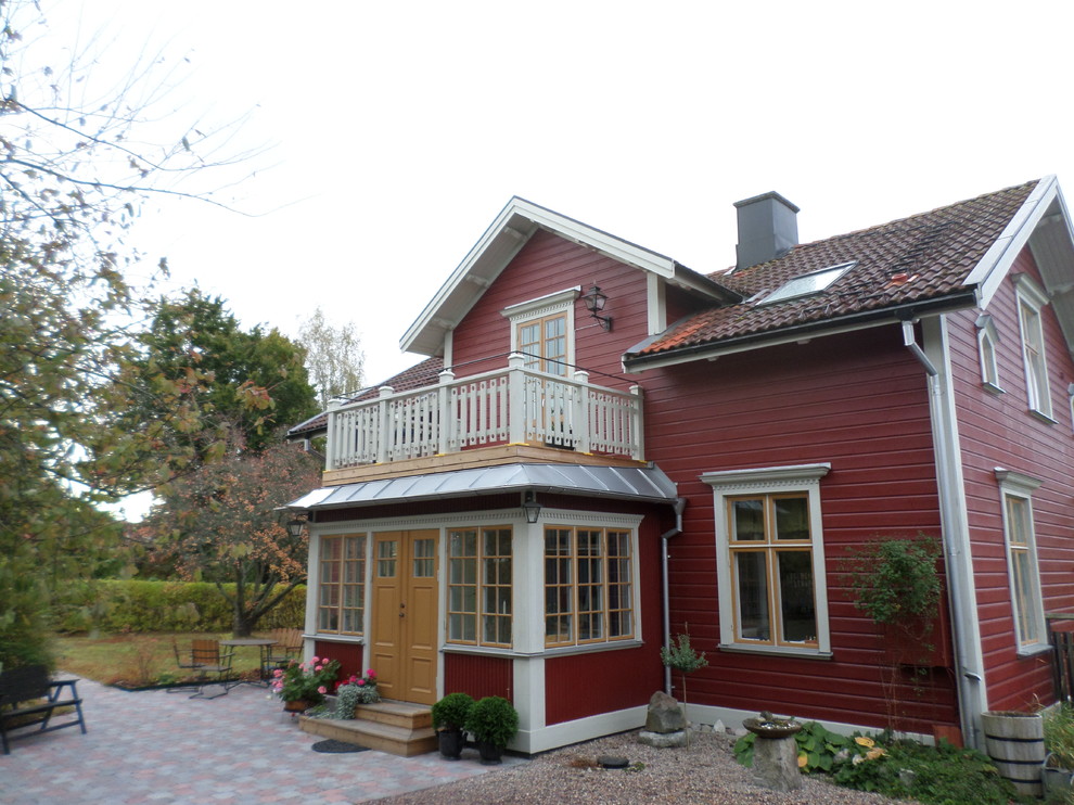Ispirazione per la facciata di una casa rossa country a due piani con rivestimento in legno