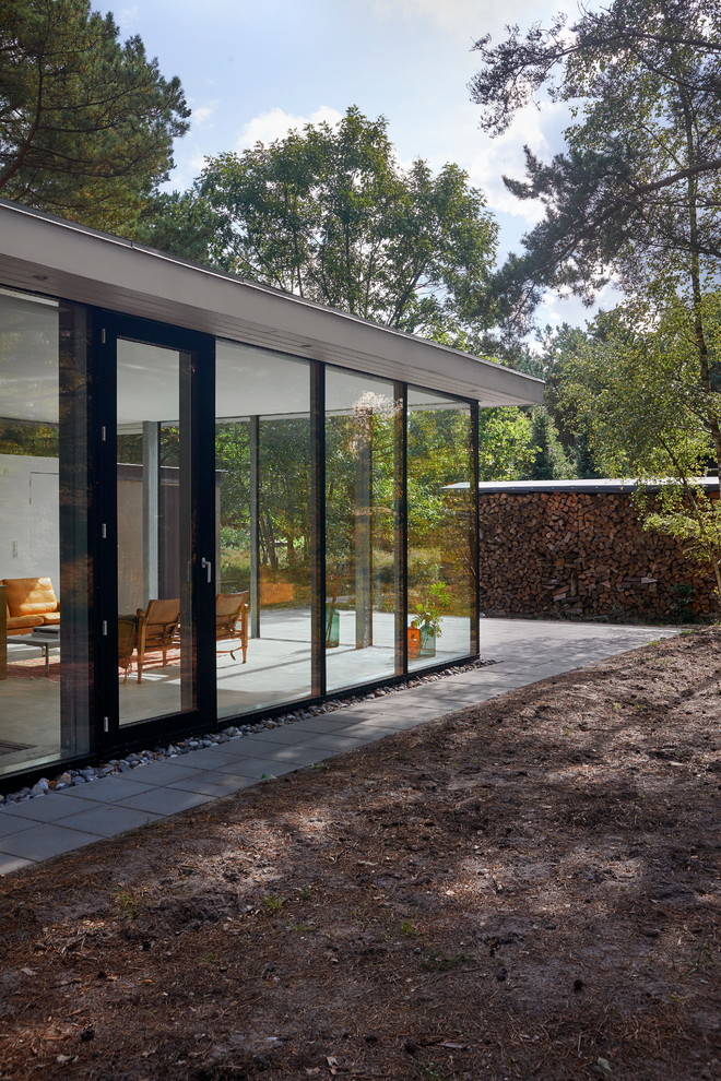 Foto på ett minimalistiskt hus, med glasfasad