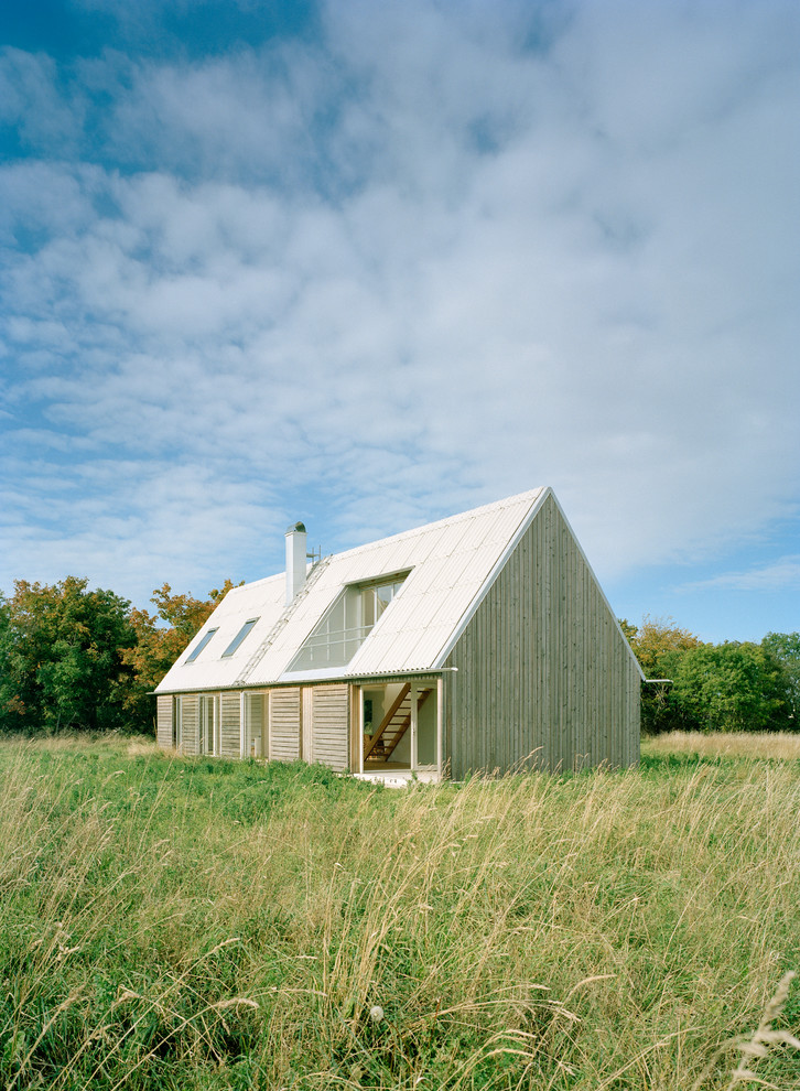 Esempio della facciata di una casa beige scandinava a due piani di medie dimensioni con rivestimento in legno e tetto a capanna