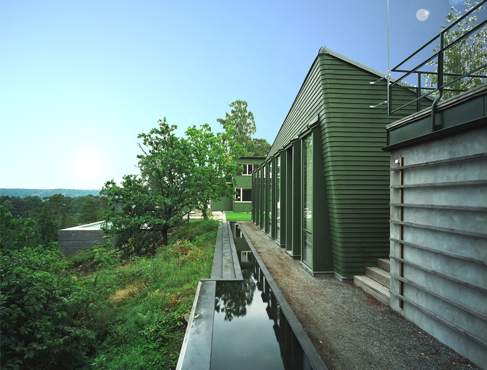 Modern inredning av ett mellanstort grönt hus, med allt i ett plan, tak i metall och sadeltak
