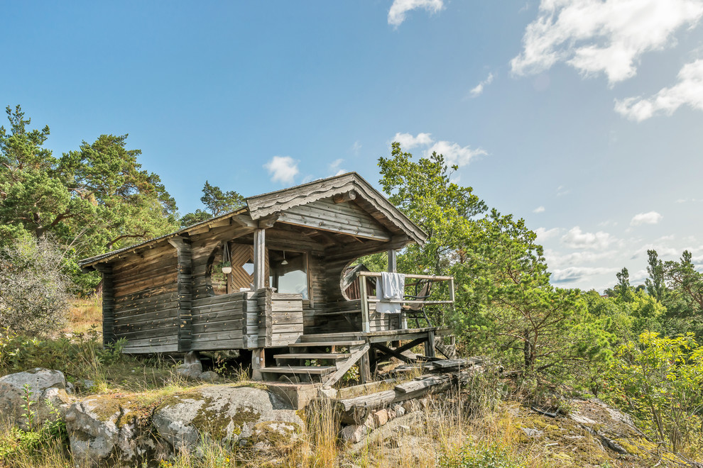 Small rustic bungalow detached house in Stockholm with wood cladding and a pitched roof.