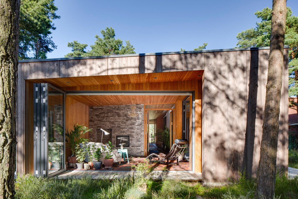 Diseño de fachada de casa nórdica de una planta con revestimiento de madera y tejado de un solo tendido