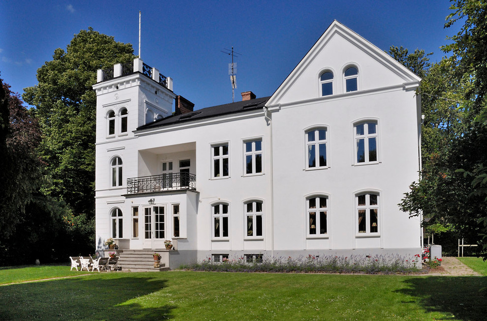 Geräumiges, Dreistöckiges Klassisches Haus mit Lehmfassade, weißer Fassadenfarbe und Satteldach in Stockholm