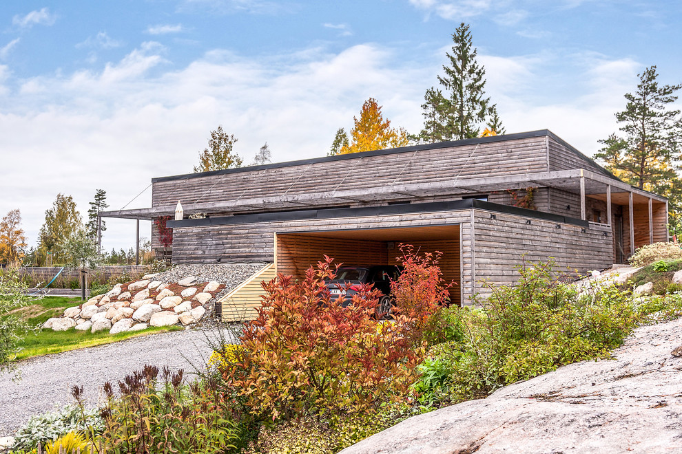 Diseño de fachada de casa gris escandinava de tamaño medio de una planta con revestimiento de madera y tejado de un solo tendido