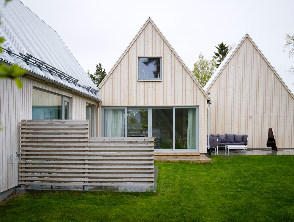 Idée de décoration pour une façade de maison de ville beige nordique en bois de taille moyenne.