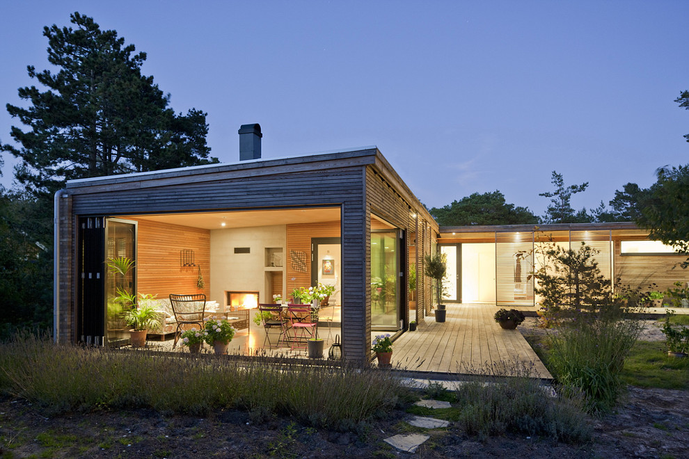Idée de décoration pour une grande façade de maison beige design en bois de plain-pied avec un toit plat.