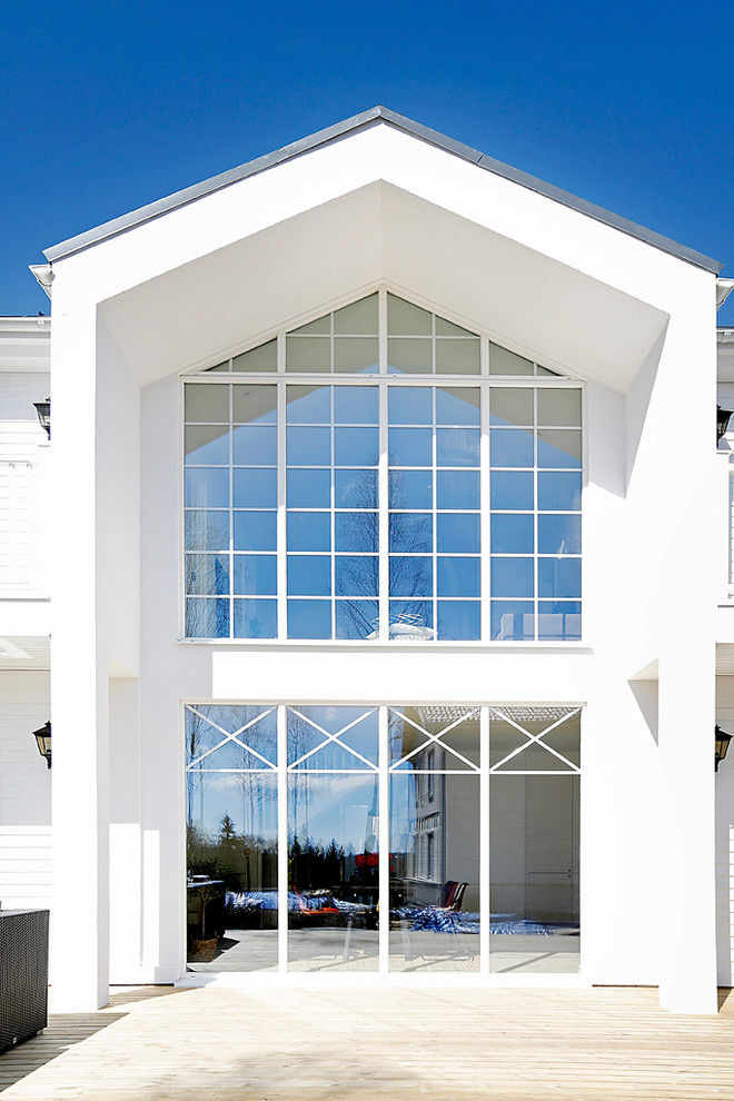 На фото: огромный, двухэтажный, белый дом в стиле неоклассика (современная классика) с двускатной крышей