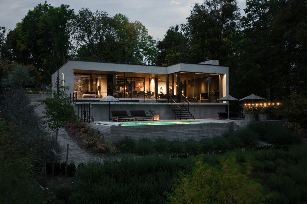 Ejemplo de fachada de casa gris minimalista con revestimiento de vidrio