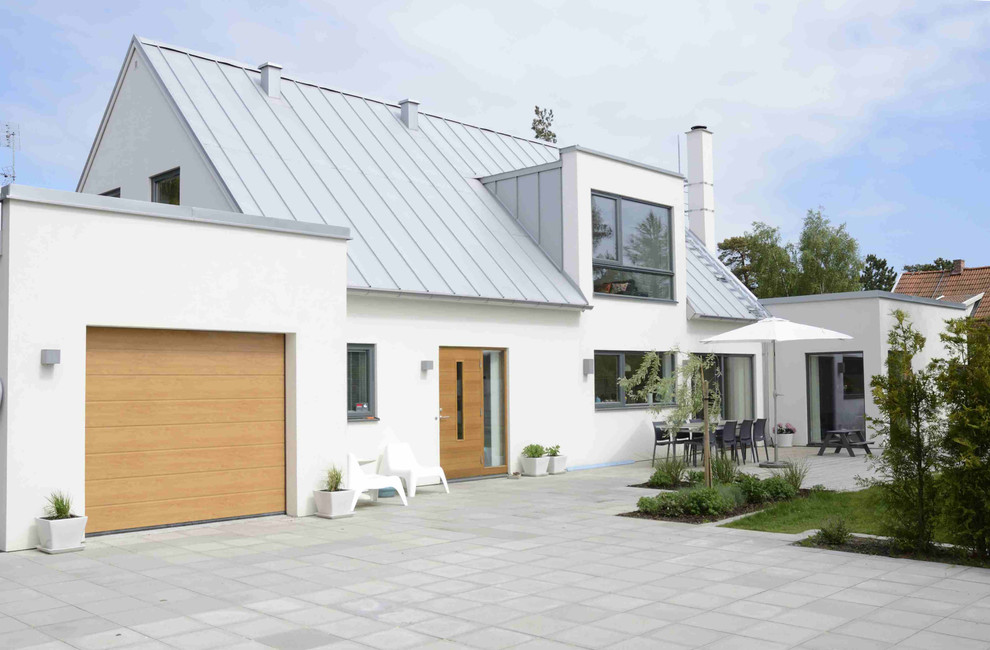 Modelo de fachada blanca nórdica grande de dos plantas con tejado a dos aguas y revestimiento de hormigón