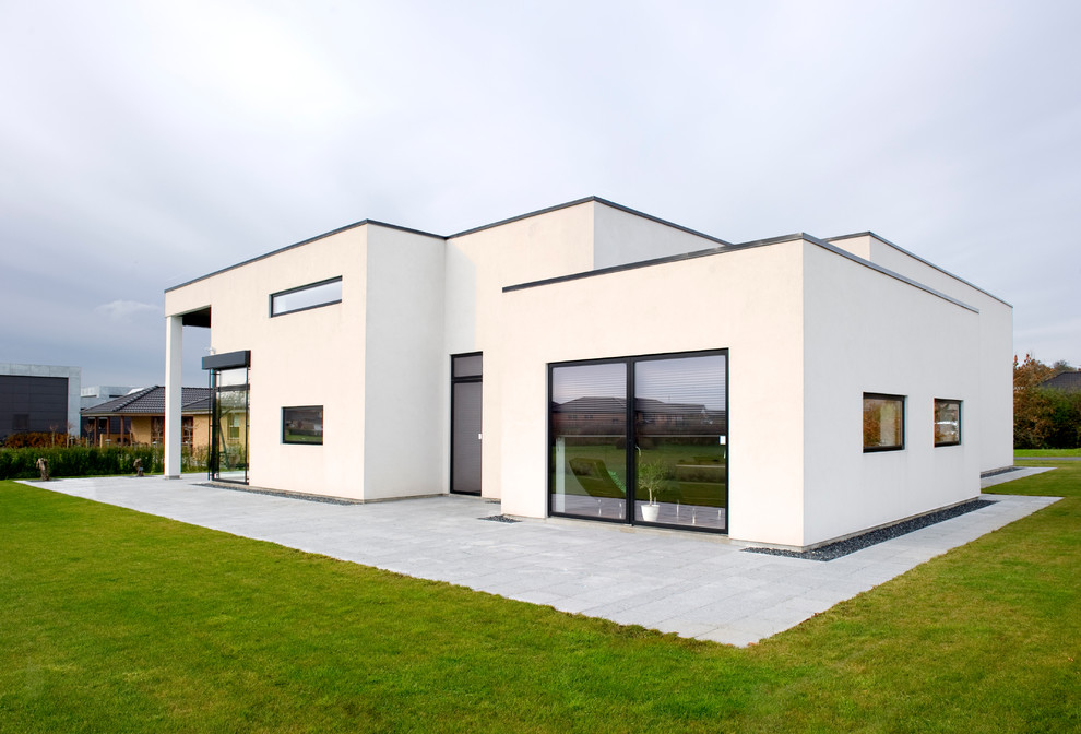 Diseño de fachada blanca minimalista grande de una planta con revestimiento de ladrillo y tejado plano