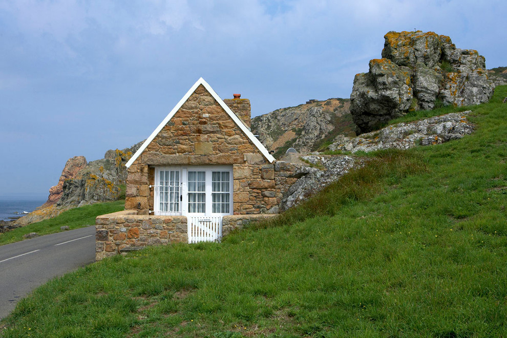 Cette image montre une petite façade de maison multicolore nordique en pierre de plain-pied avec un toit à croupette.