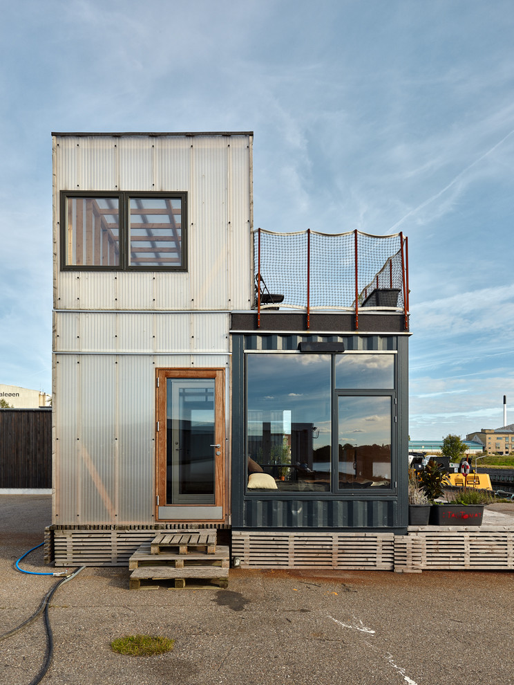 Idee per la facciata di una casa industriale a due piani con rivestimento in metallo e tetto piano