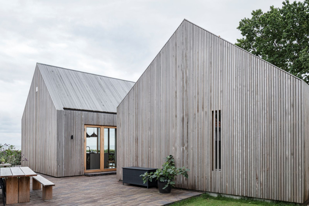Идея дизайна: одноэтажный, деревянный, коричневый дуплекс среднего размера в стиле модернизм с двускатной крышей, коричневой крышей и отделкой планкеном