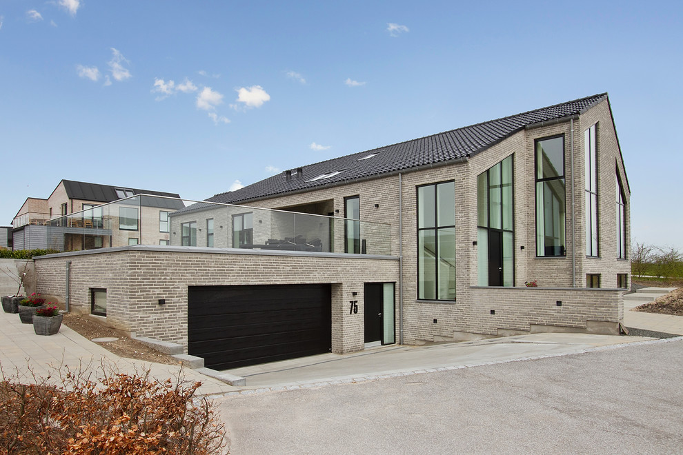 Large danish gray two-story brick exterior home photo in Aarhus