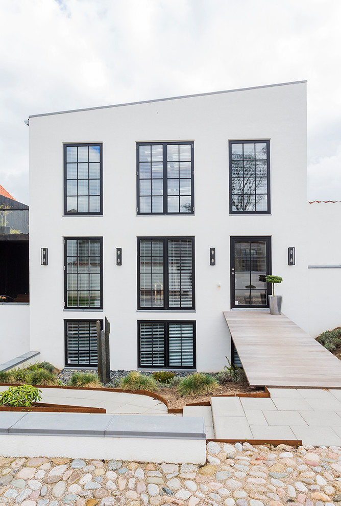 Großes, Dreistöckiges Modernes Einfamilienhaus mit weißer Fassadenfarbe, Putzfassade und Pultdach in Sonstige