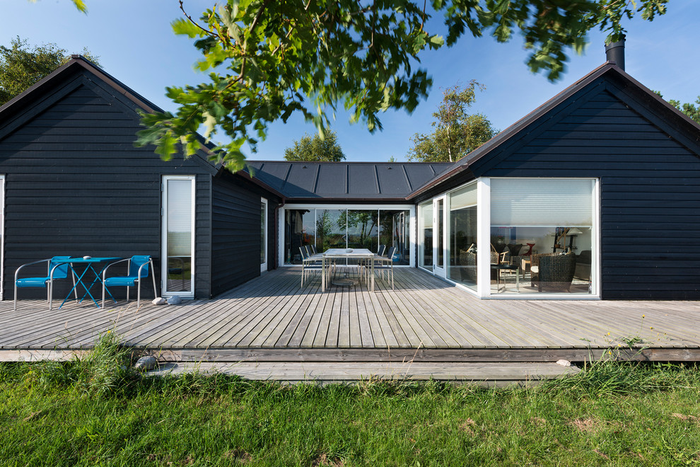 Inspiration for a large and black scandi bungalow house exterior in Other with a pitched roof and wood cladding.