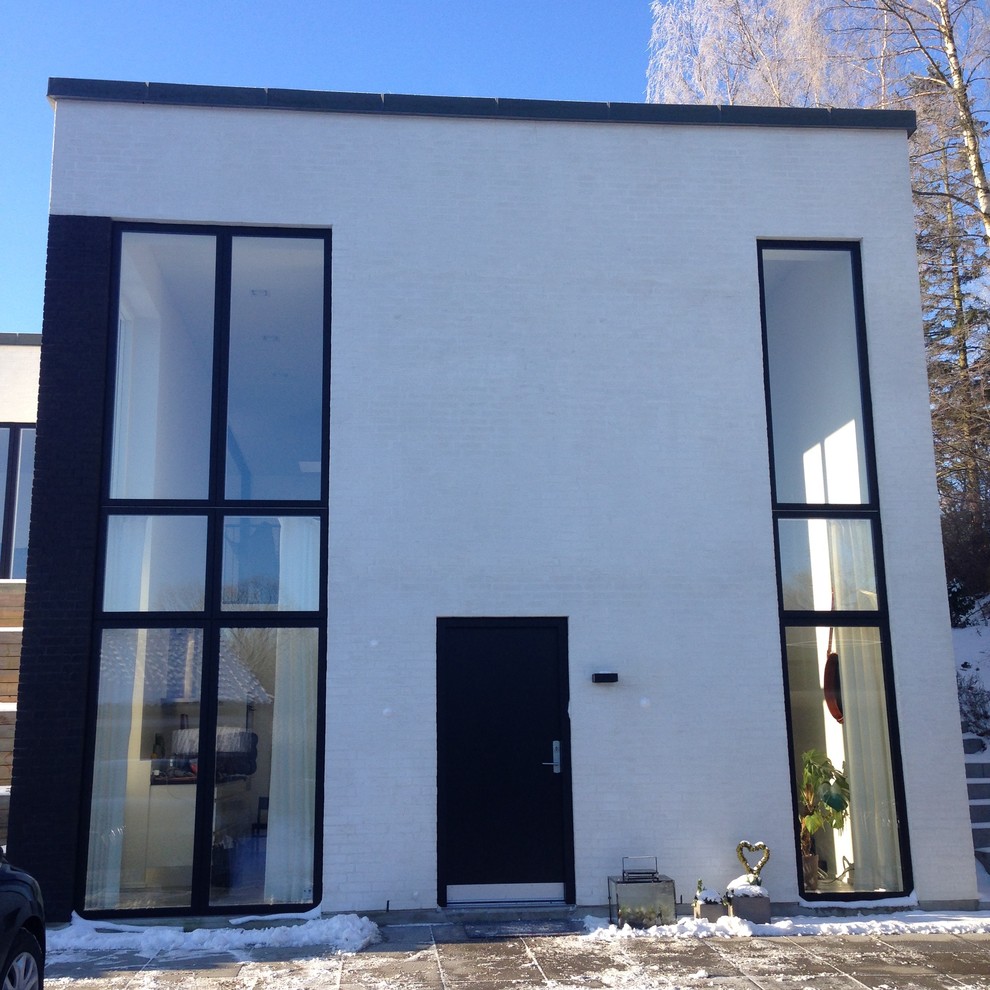Zweistöckiges Skandinavisches Einfamilienhaus mit Backsteinfassade, weißer Fassadenfarbe und Flachdach in Kopenhagen