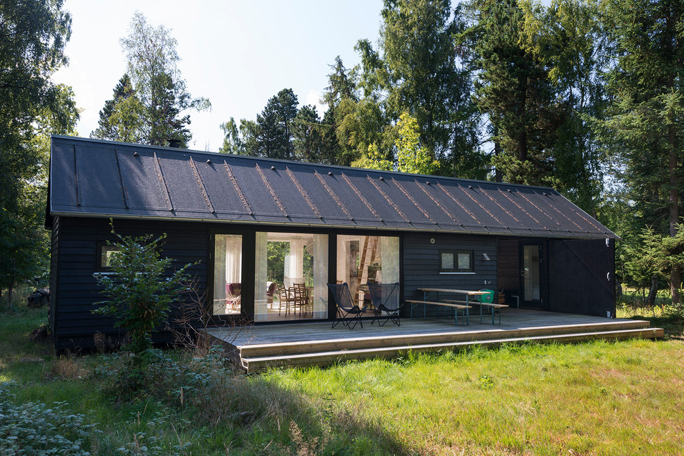 Idée de décoration pour une façade de maison noire nordique en bois de plain-pied et de taille moyenne avec un toit à deux pans.