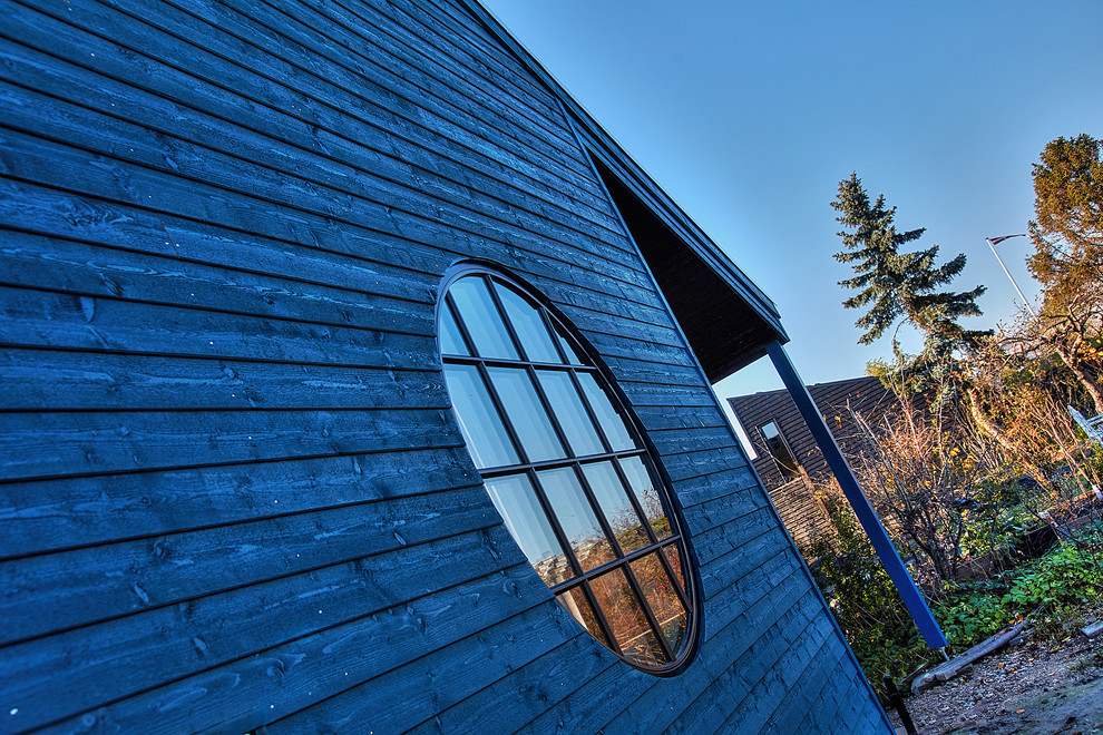 Idées déco pour une façade de maison bleue éclectique en bois de taille moyenne et de plain-pied.
