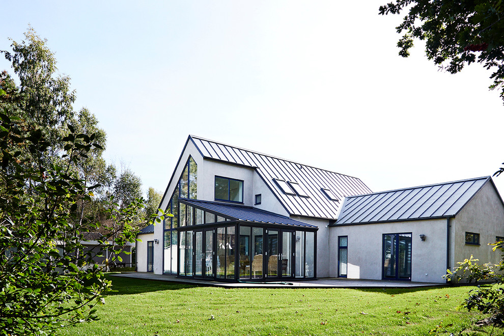 На фото: серый, двухэтажный дом среднего размера в современном стиле с двускатной крышей и облицовкой из ЦСП с