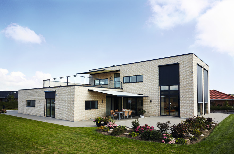 Idee per la facciata di una casa grande beige contemporanea a piani sfalsati con rivestimento in mattoni e tetto piano