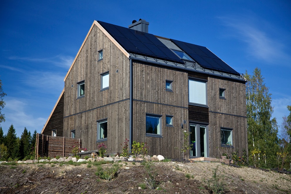 Exemple d'une façade de maison marron scandinave en bois à deux étages et plus avec un toit à deux pans.