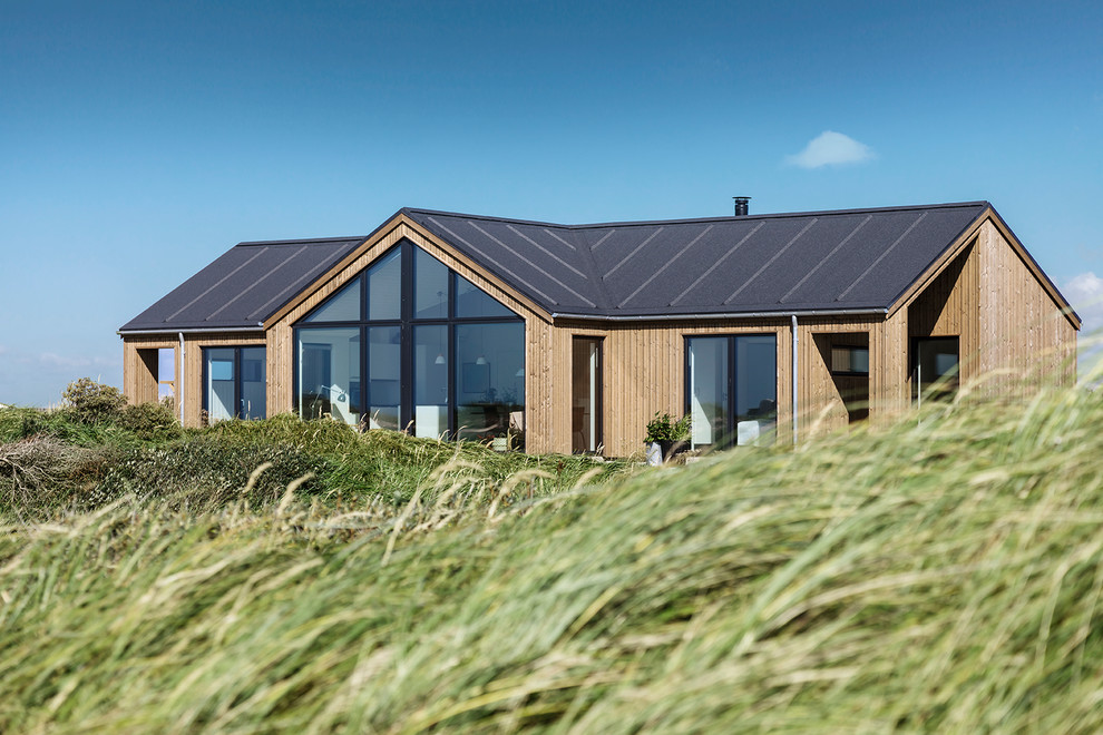 Inspiration pour une façade de maison marron traditionnelle en bois de taille moyenne et de plain-pied avec un toit à deux pans et un toit mixte.
