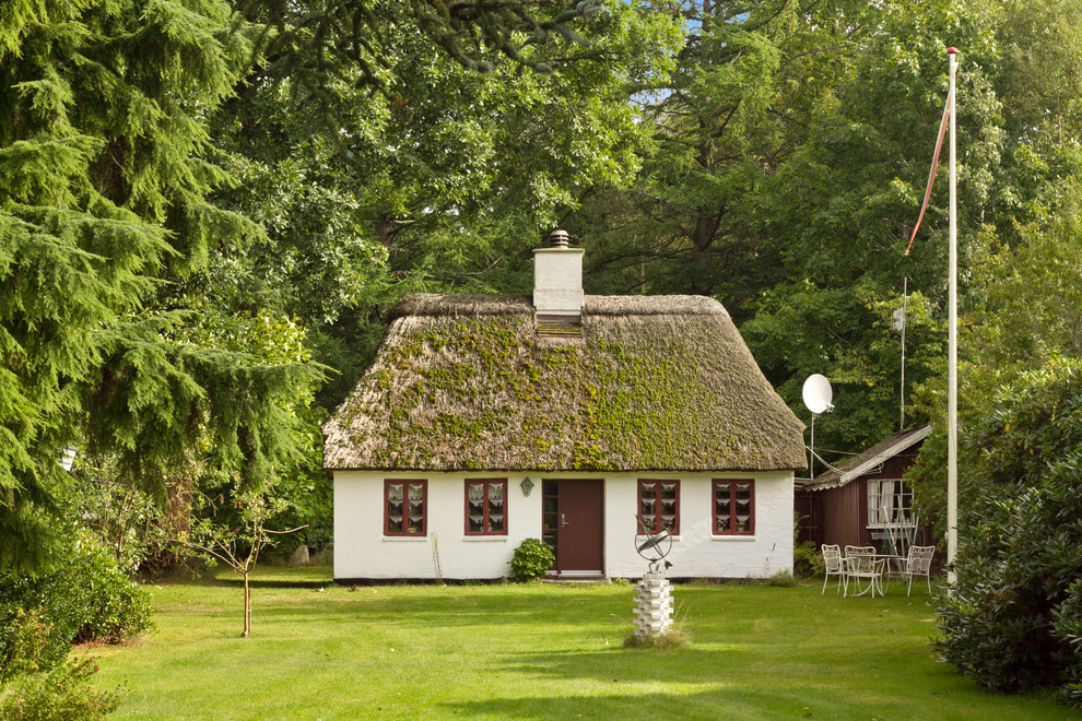 На фото: одноэтажный, белый, кирпичный дом среднего размера в скандинавском стиле с двускатной крышей