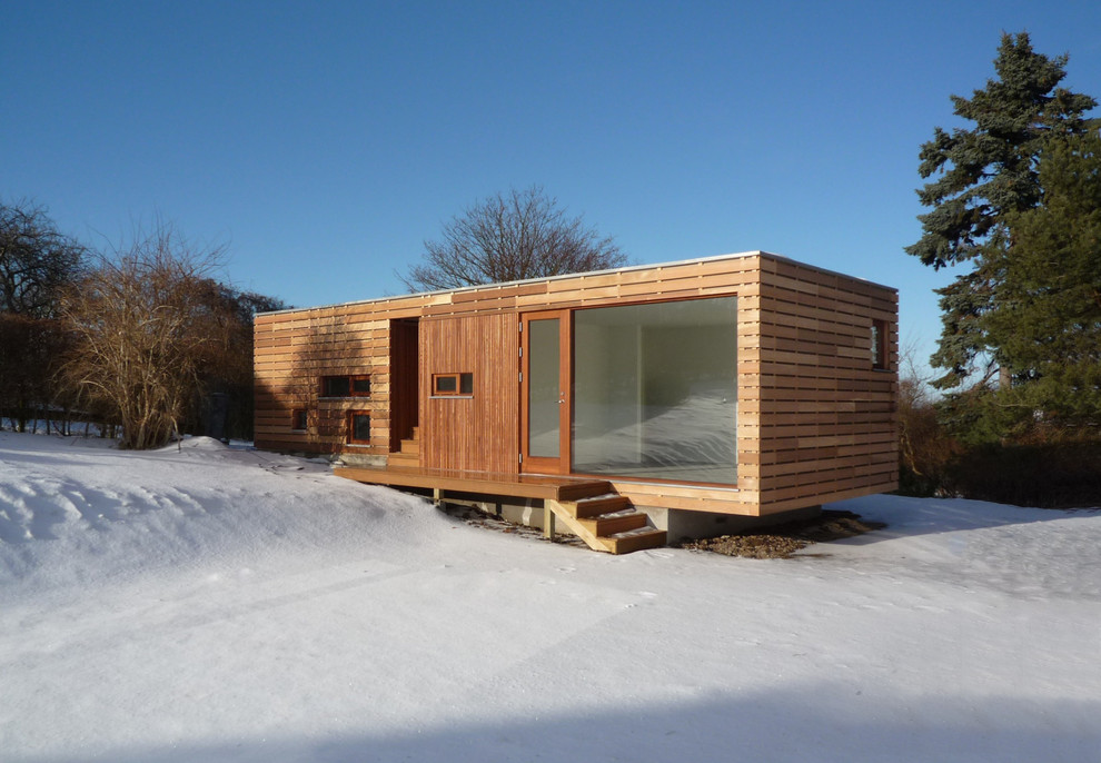 Imagen de fachada marrón escandinava pequeña de una planta con revestimiento de madera y tejado plano
