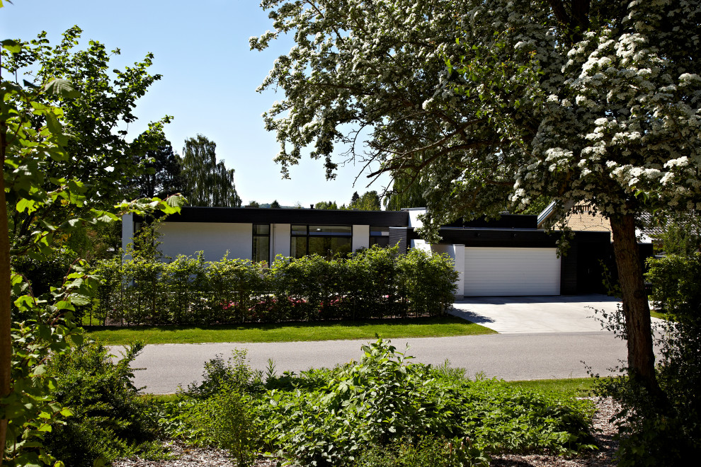 Diseño de fachada de casa blanca y negra minimalista grande a niveles con ladrillo pintado y tejado plano