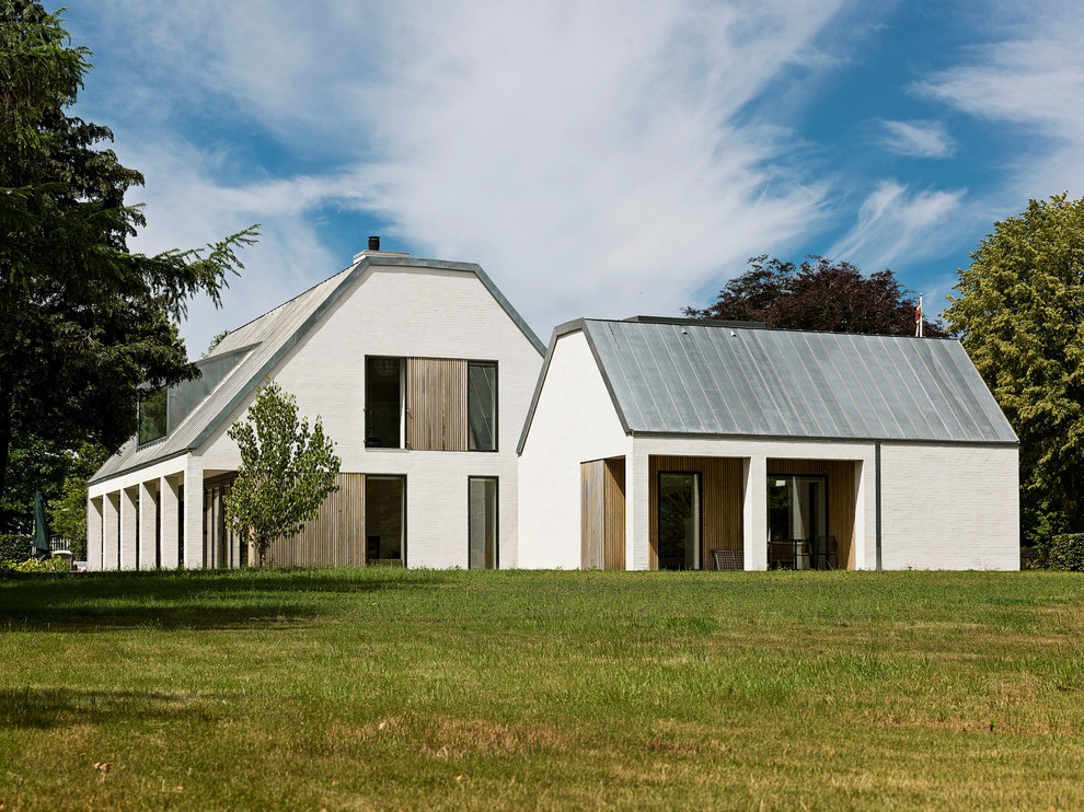 Свежая идея для дизайна: двухэтажный, белый частный загородный дом в скандинавском стиле с полувальмовой крышей и металлической крышей - отличное фото интерьера