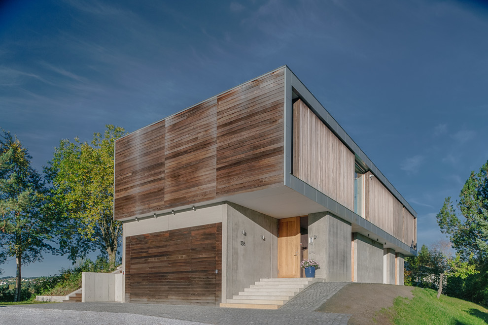 Cette image montre une façade de maison design en bois à un étage avec un toit plat.
