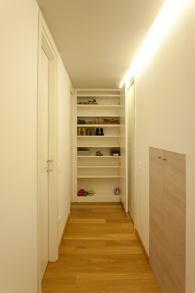 Exemple d'un petit couloir tendance avec un mur blanc et un sol en bois brun.