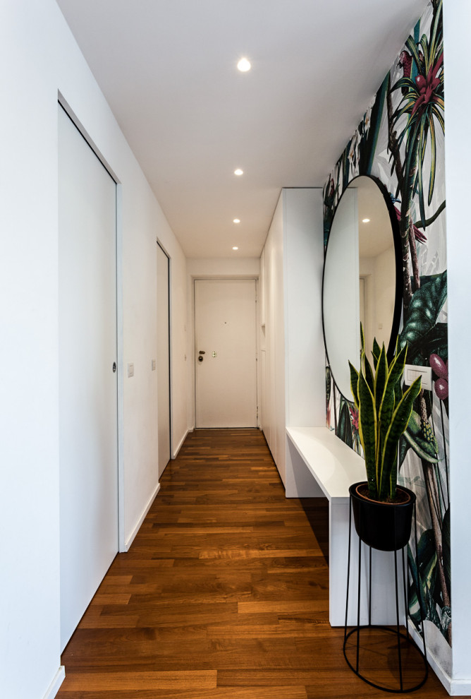 Kleines Foyer mit weißer Wandfarbe, dunklem Holzboden, Einzeltür, weißer Haustür, braunem Boden und eingelassener Decke in Mailand