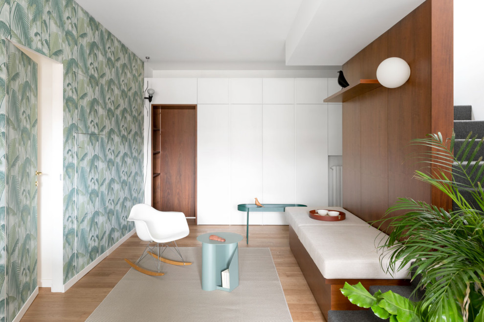 Example of a large danish light wood floor and wallpaper entryway design in Milan with white walls