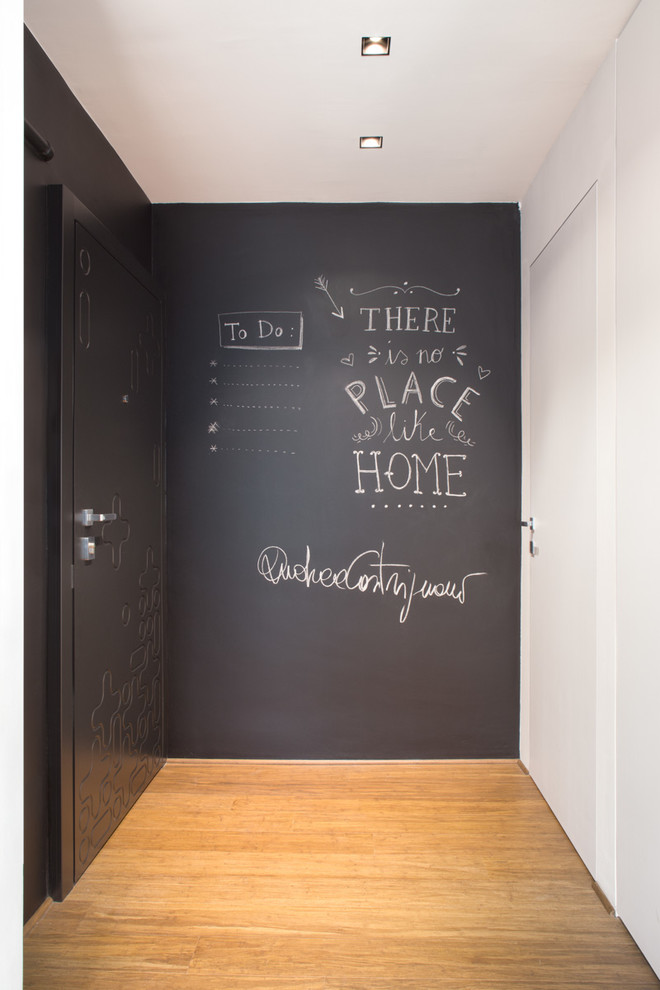 Esempio di un ingresso shabby-chic style con pareti grigie, pavimento in legno massello medio e una porta nera