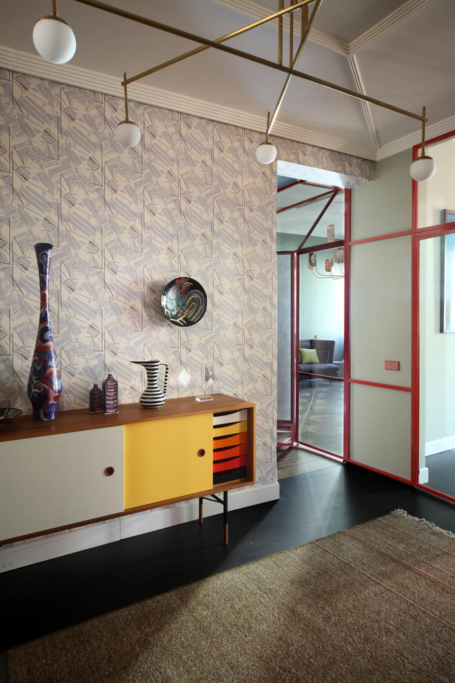 Esempio di un ingresso minimalista con pareti beige, pavimento nero e una porta rossa