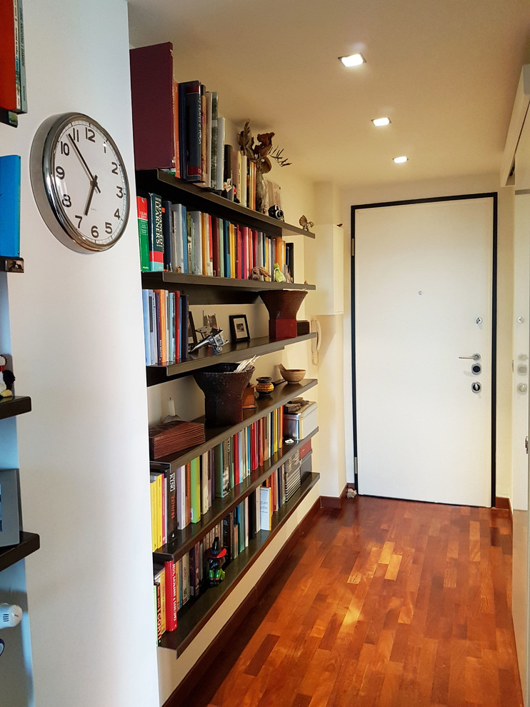 Inspiration pour un petit hall d'entrée design avec un mur blanc, un sol en bois brun, une porte simple et une porte blanche.