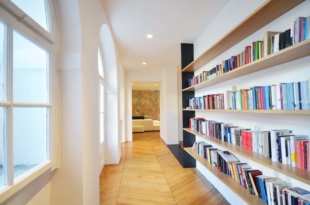 Imagen de recibidores y pasillos mediterráneos con paredes blancas, suelo de madera clara y suelo beige