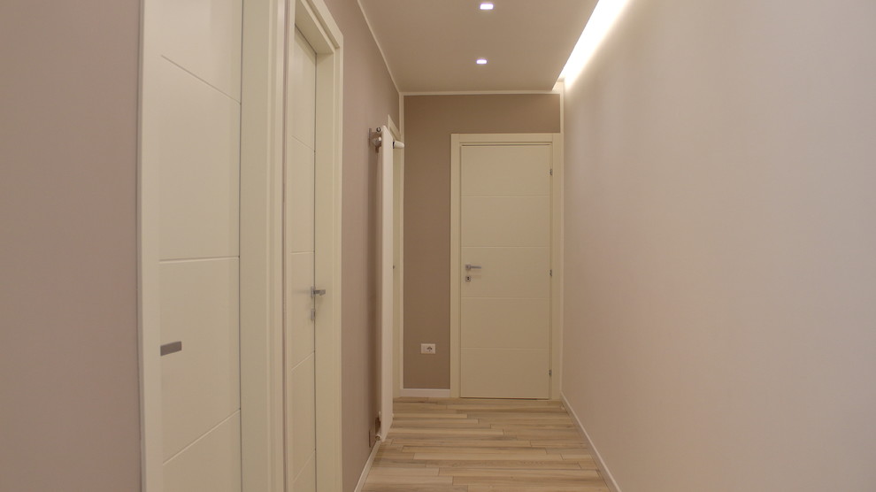 Aménagement d'un couloir contemporain de taille moyenne avec un mur beige et un sol en carrelage de porcelaine.