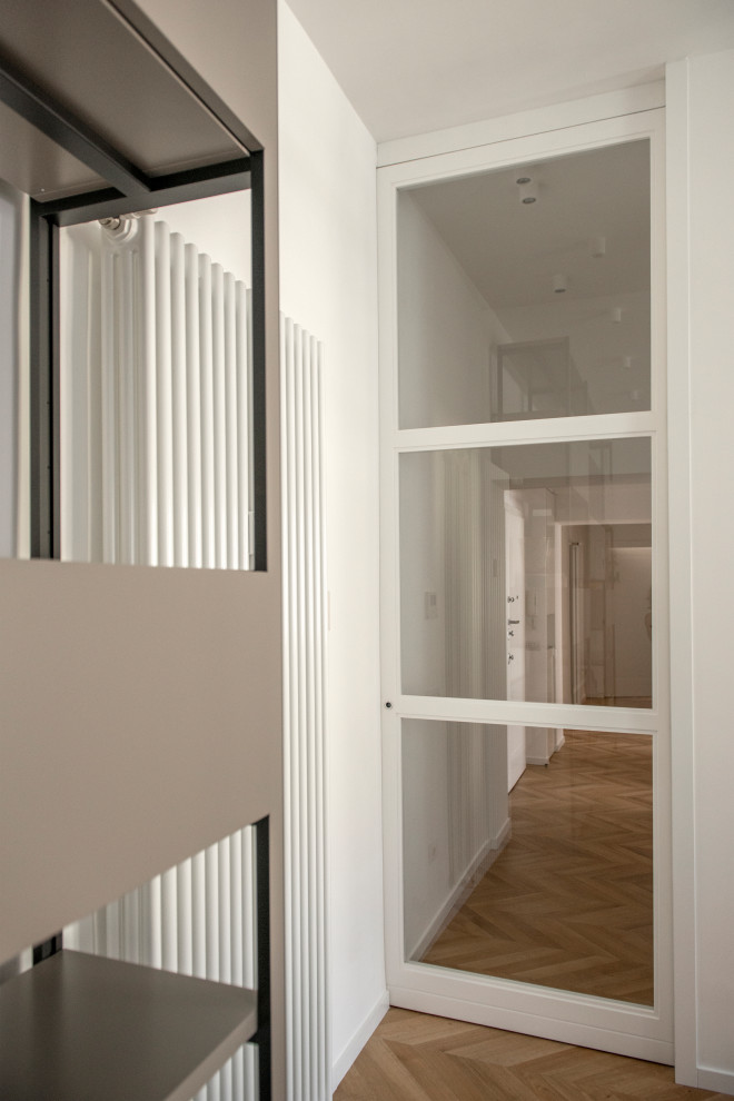 Idee per un ingresso o corridoio design di medie dimensioni con pareti bianche, pavimento in legno massello medio e pavimento marrone