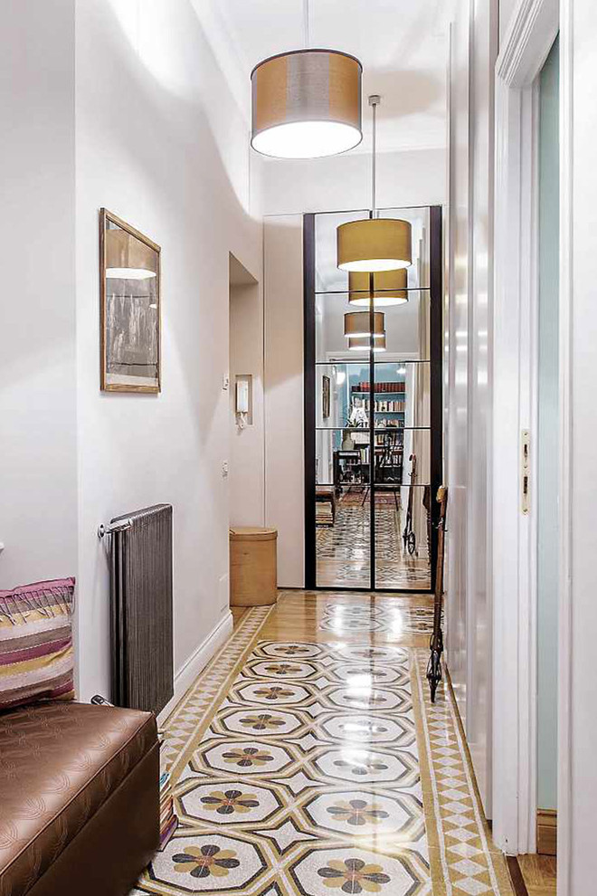 На фото: маленький коридор в стиле фьюжн с белыми стенами, бетонным полом и разноцветным полом для на участке и в саду